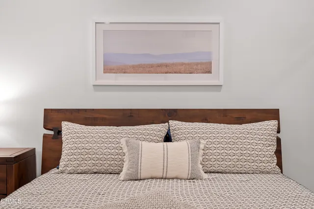 a bedroom with a bed and a painting on the wall