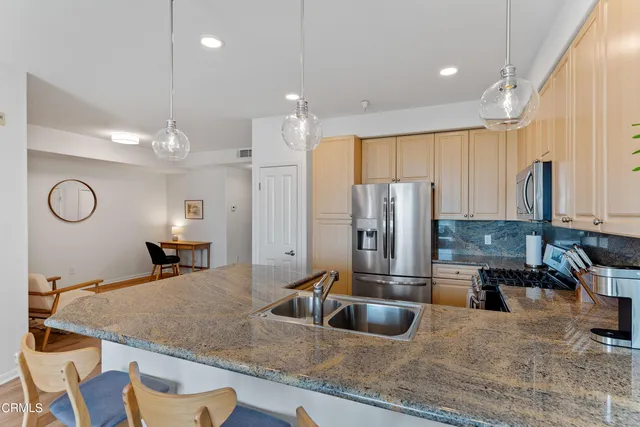 a kitchen with stainless steel appliances granite countertop a sink refrigerator and cabinets