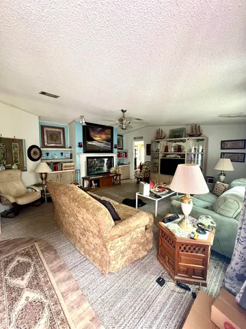 a living room with furniture a flat screen tv and kitchen view