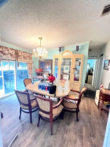 a living room with furniture a chandelier and a dining table