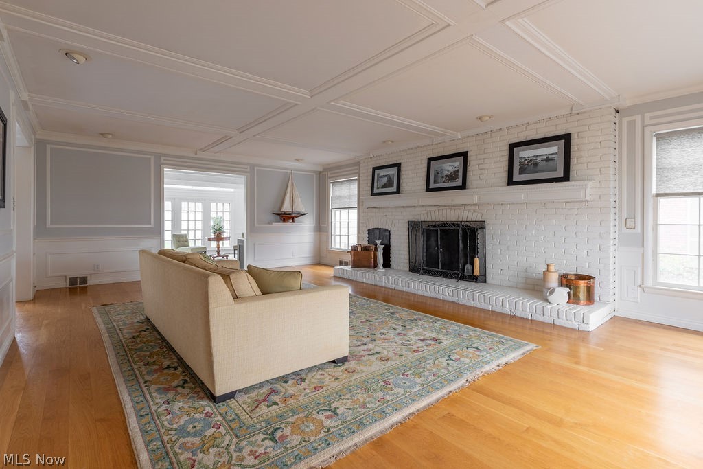 The huge living room features a wood burning fireplace and hardwood flooring. And that coffered ceiling!