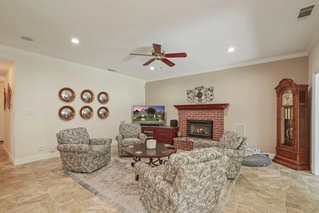a living room with furniture a fireplace and a chandelier