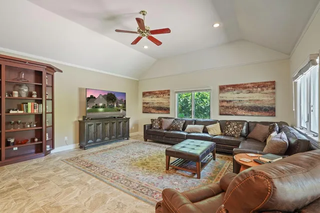 a living room with furniture a ceiling fan and a window