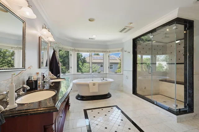 a spacious bathroom with a granite countertop tub sink and mirror
