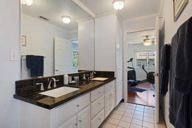 a bathroom with double sink and two mirror