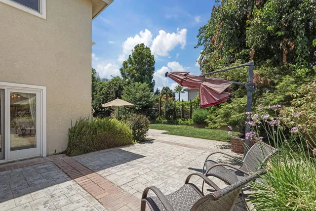 a view of a patio with table and chairs under an umbrella