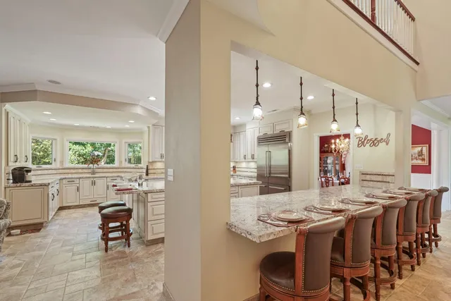 a open kitchen with stainless steel appliances kitchen island granite countertop a table and chairs in it