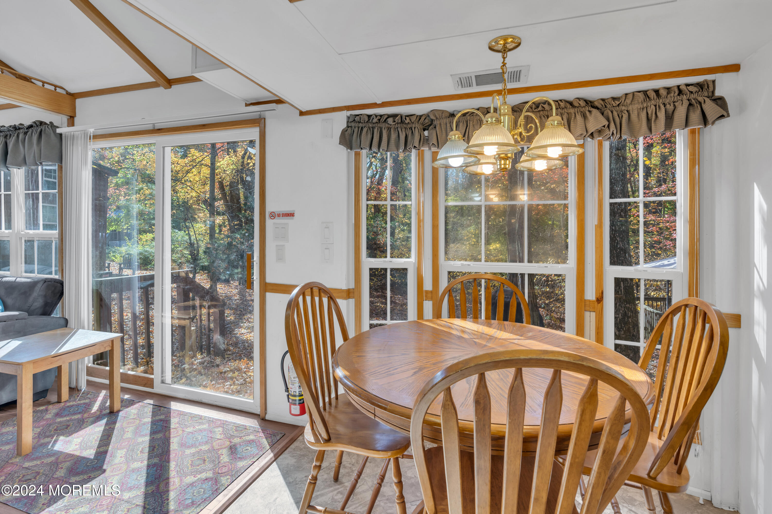 724 Monmouth Road, Unit 40 Cream Ridge, NJ 08514 - Photo 11 of 33 a view of a dining room with furniture large windows and wooden floor