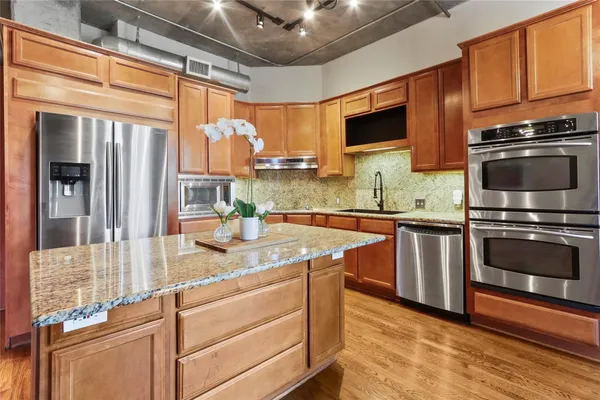a kitchen with stainless steel appliances granite countertop a sink a stove and a microwave oven