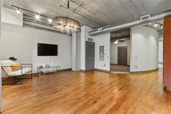 a view of a kitchen with stainless steel appliances wooden floor and chandelier