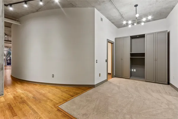 an empty room with closet and windows