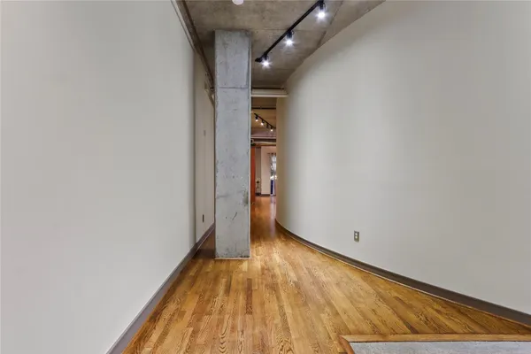 a view of empty room with wooden floor