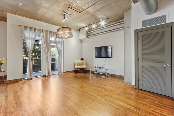 a view of a livingroom with wooden floor and furniture