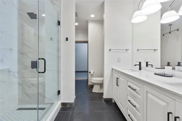 a spacious bathroom with a double vanity sink toilet and shower
