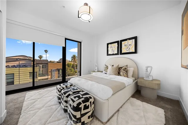 a spacious bedroom with a bed a dresser and potted plants