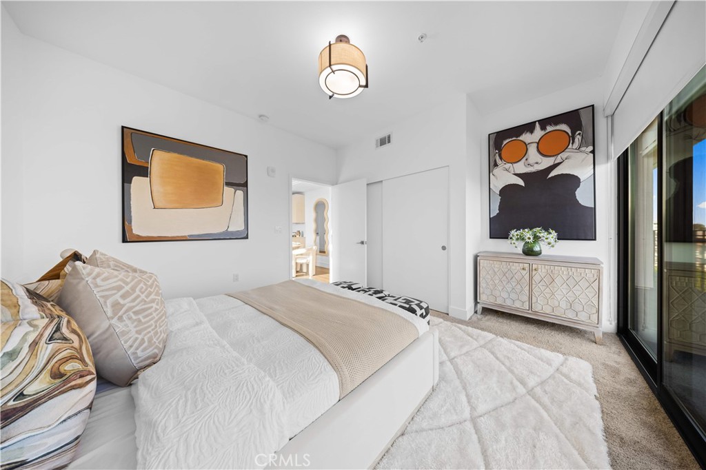 218 North El Molino Avenue, Unit 502 Pasadena, CA 91101 - Photo 10 of 35 a bedroom with a bed and a chandelier