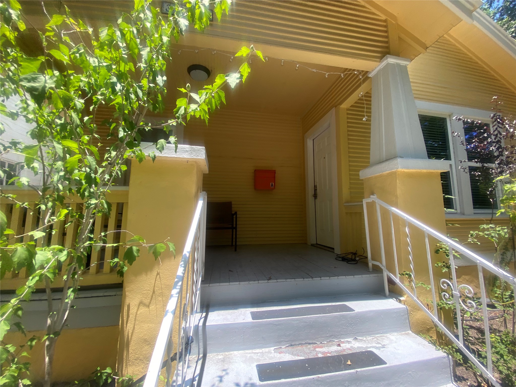 3010 Fruth Street, Unit A Austin, TX 78705 - Photo 39 of 39 A welcoming front porch features a classic white railing and bright yellow siding.