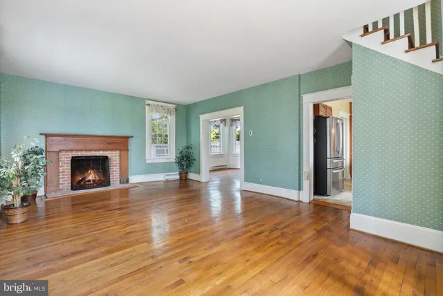 a view of empty room with fireplace and wooden floor