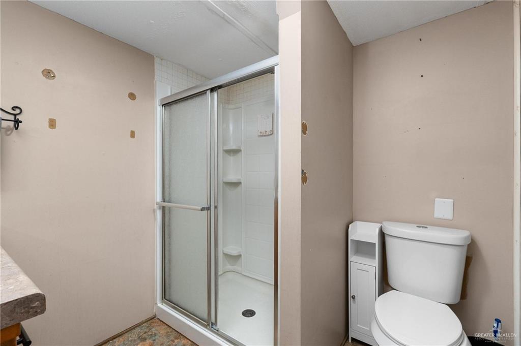 14610 Oak Street Harlingen, TX 78552 - Photo 12 of 16 Bathroom featuring toilet and a stall shower