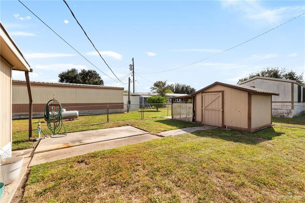 14610 Oak Street Harlingen, TX 78552 - Photo 16 of 16 Fenced backyard with a storage shed and a gate
