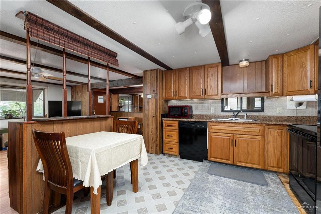 14610 Oak Street Harlingen, TX 78552 - Photo 5 of 16 Kitchen with brown cabinetry, beam ceiling, a ceiling fan, black appliances, and light flooring