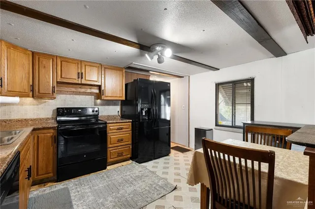 a kitchen with stainless steel appliances granite countertop a refrigerator a stove top oven a sink dishwasher and wooden cabinets