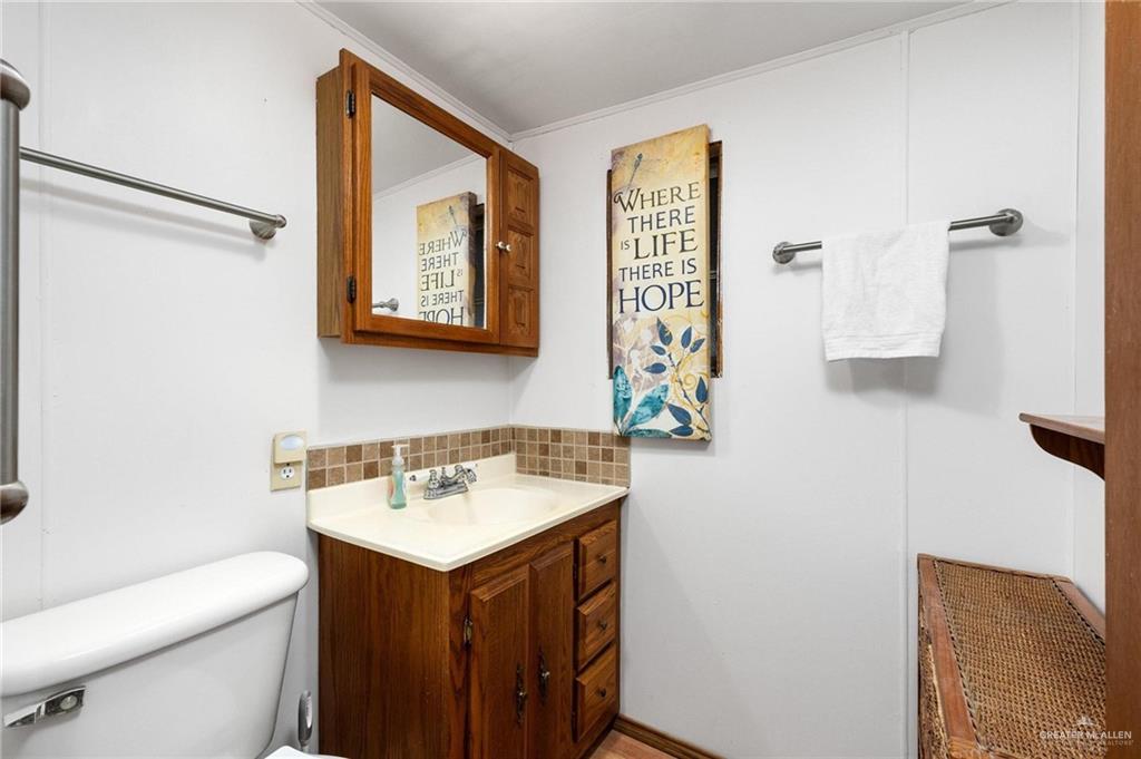 14610 Oak Street Harlingen, TX 78552 - Photo 9 of 16 Bathroom with tasteful backsplash, vanity, and crown molding
