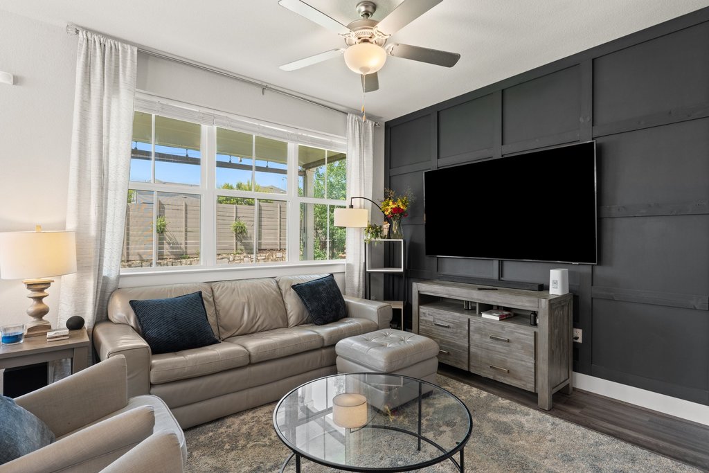 7403 Travertine Spring Drive, Unit 117 Austin, TX 78744 - Photo 3 of 37 A contemporary living area features rich dark accent walls and a spacious window overlooking the verdant outdoors.