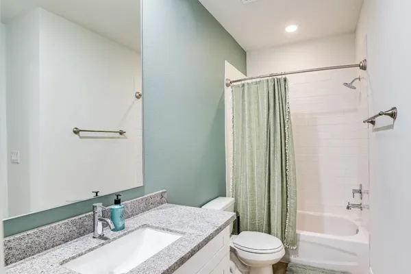 a bathroom with a granite countertop sink toilet and shower