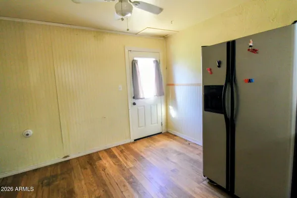 a kitchen with granite countertop a stove top oven a sink dishwasher and a refrigerator with wooden floor