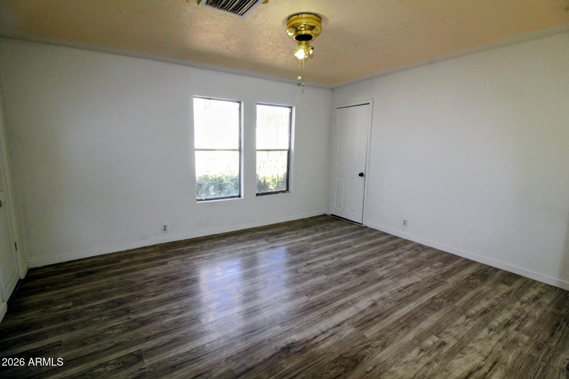 5733 Globe Canyon Road Globe, AZ 85501 - Photo 26 of 30 an empty room with wooden floor and windows