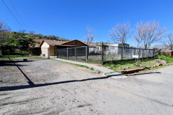 a view of a house with a yard and fence