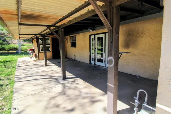 a view of a porch with a table and chairs and potted plants