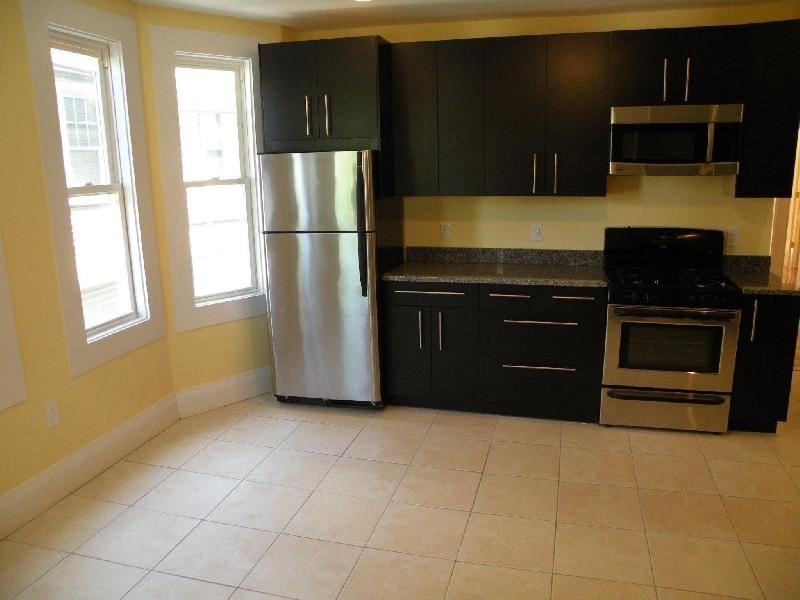 3147-3149 Washington Street, Unit 1 Boston, MA 02130 - Photo 3 of 6 a kitchen with stainless steel appliances granite countertop a refrigerator and a stove top oven