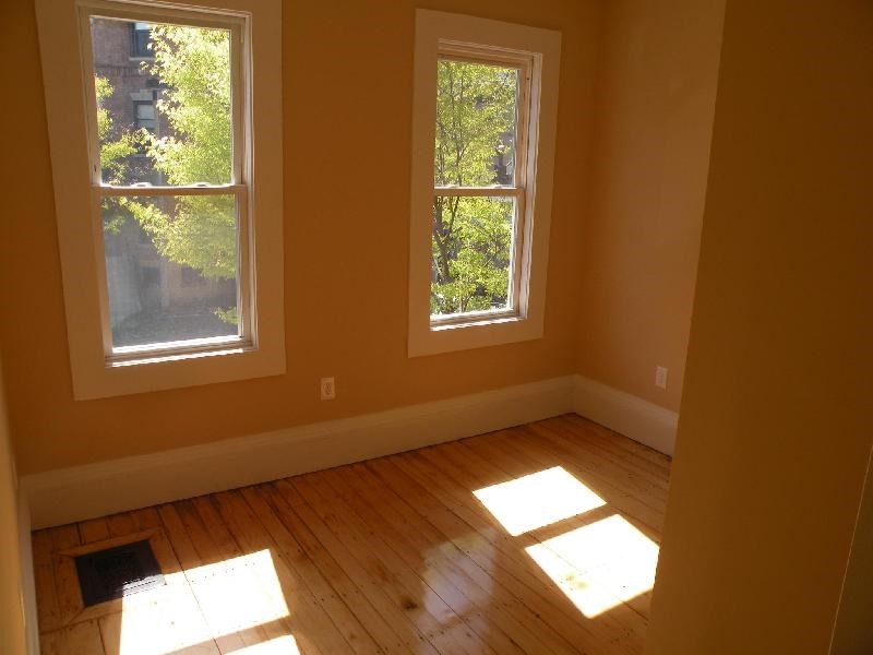 3147-3149 Washington Street, Unit 1 Boston, MA 02130 - Photo 4 of 6 an empty room with wooden floor and windows