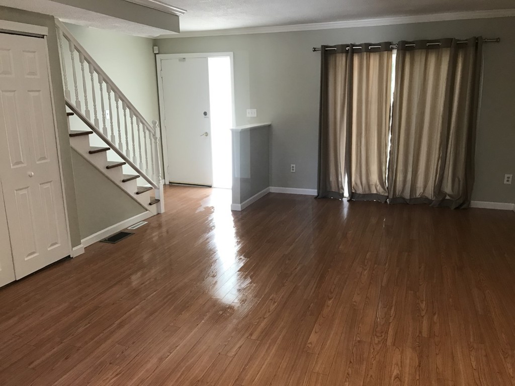 1 Markham Circle, Unit D Ayer, MA 01432 - Photo 2 of 13 a view of a hallway with wooden floor and stairs