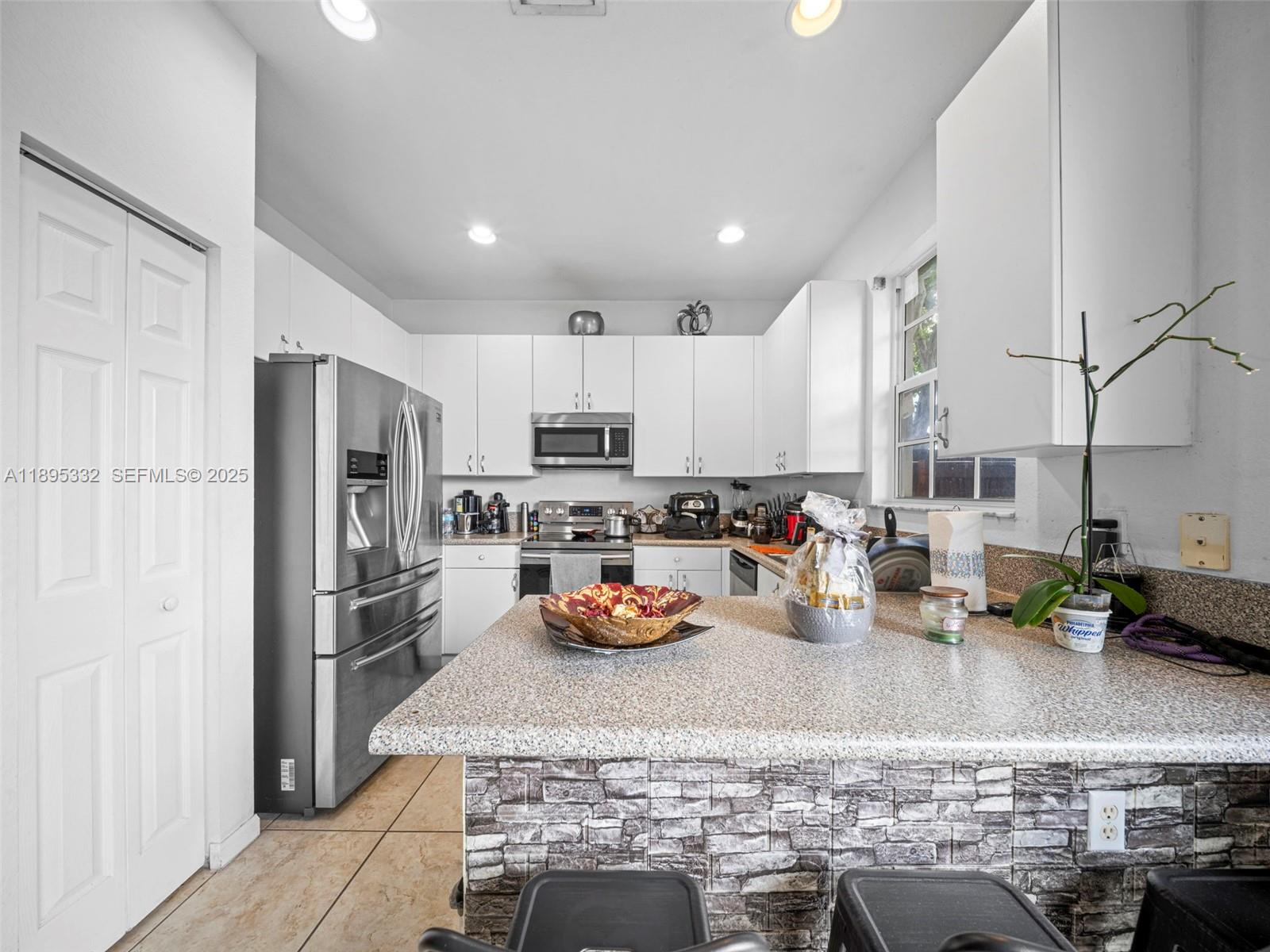 2104 Northeast 3rd Court Homestead, FL 33033 - Photo 13 of 35 a kitchen with stainless steel appliances granite countertop a refrigerator sink and stove