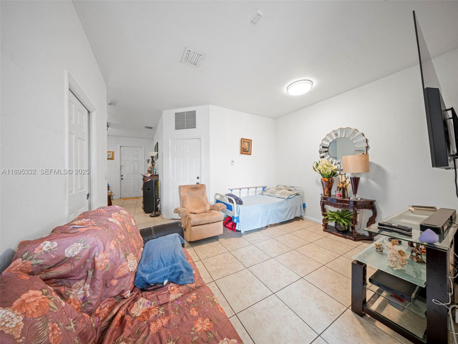 2104 Northeast 3rd Court Homestead, FL 33033 - Photo 9 of 35 a bedroom with a bed dresser and a window