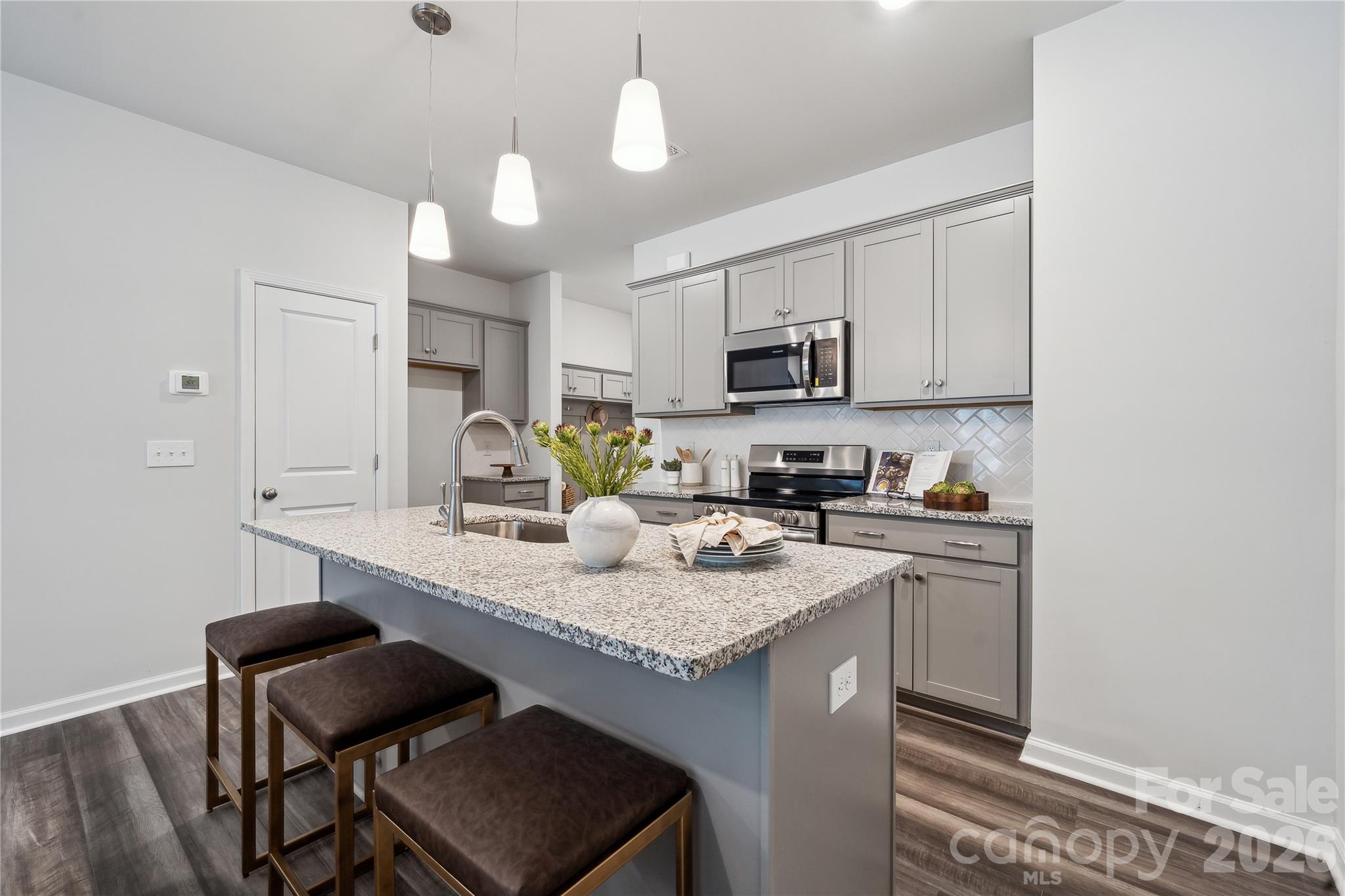 a kitchen with kitchen island granite countertop a sink cabinets and wooden floor
