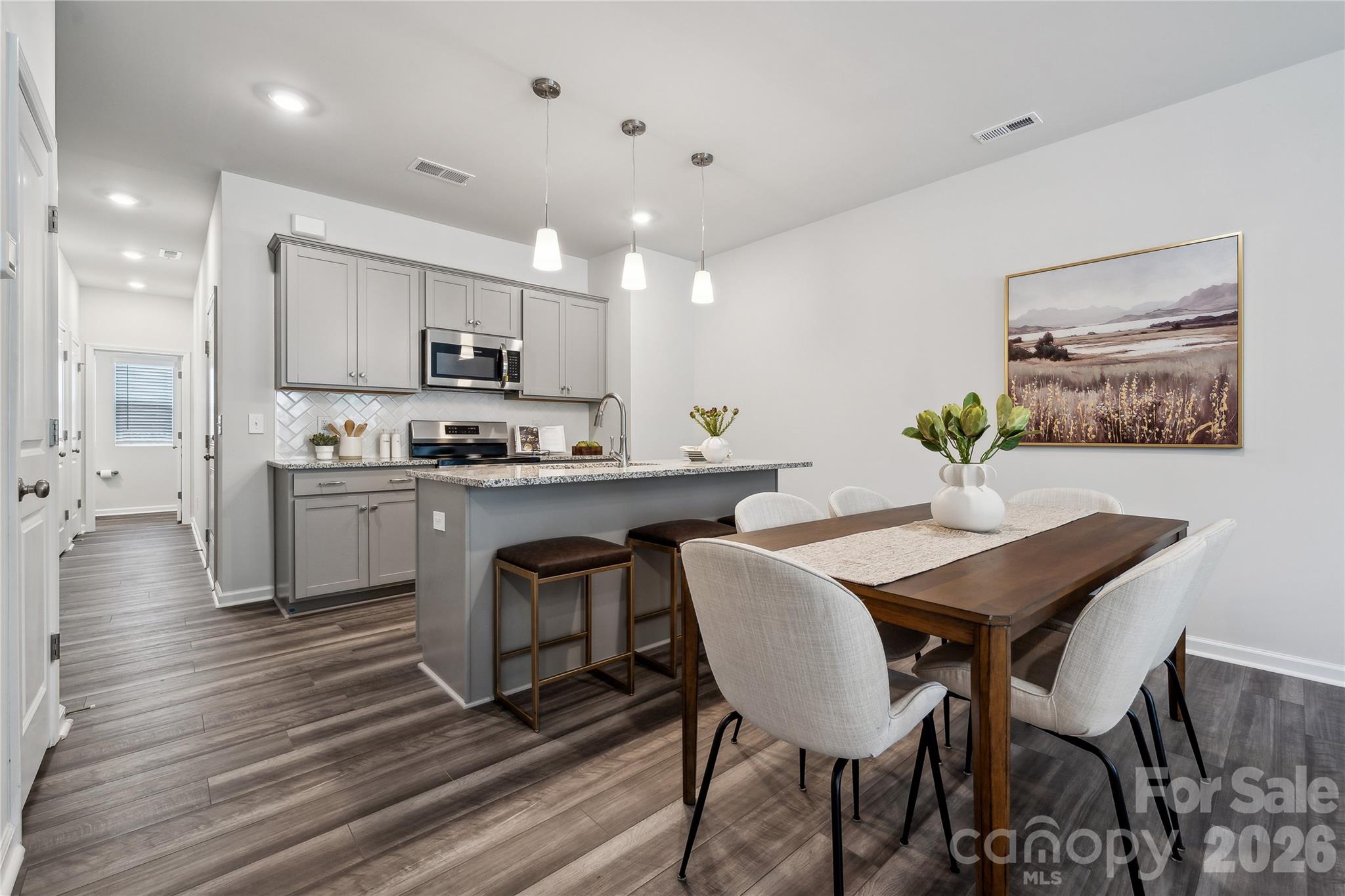 3021 Kingsfield Road, Unit 50 Charlotte, NC 28208 - Photo 2 of 8 a kitchen with stainless steel appliances kitchen island granite countertop a dining table chairs and view kitchen