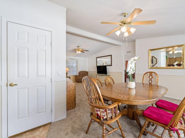 3941 West 40 North Hurricane, UT 84737 - Photo 19 of 55 Carpeted dining area featuring a paddle fan with integrated lighting, a two-tone wall finish, and an adjacent tiled entryway