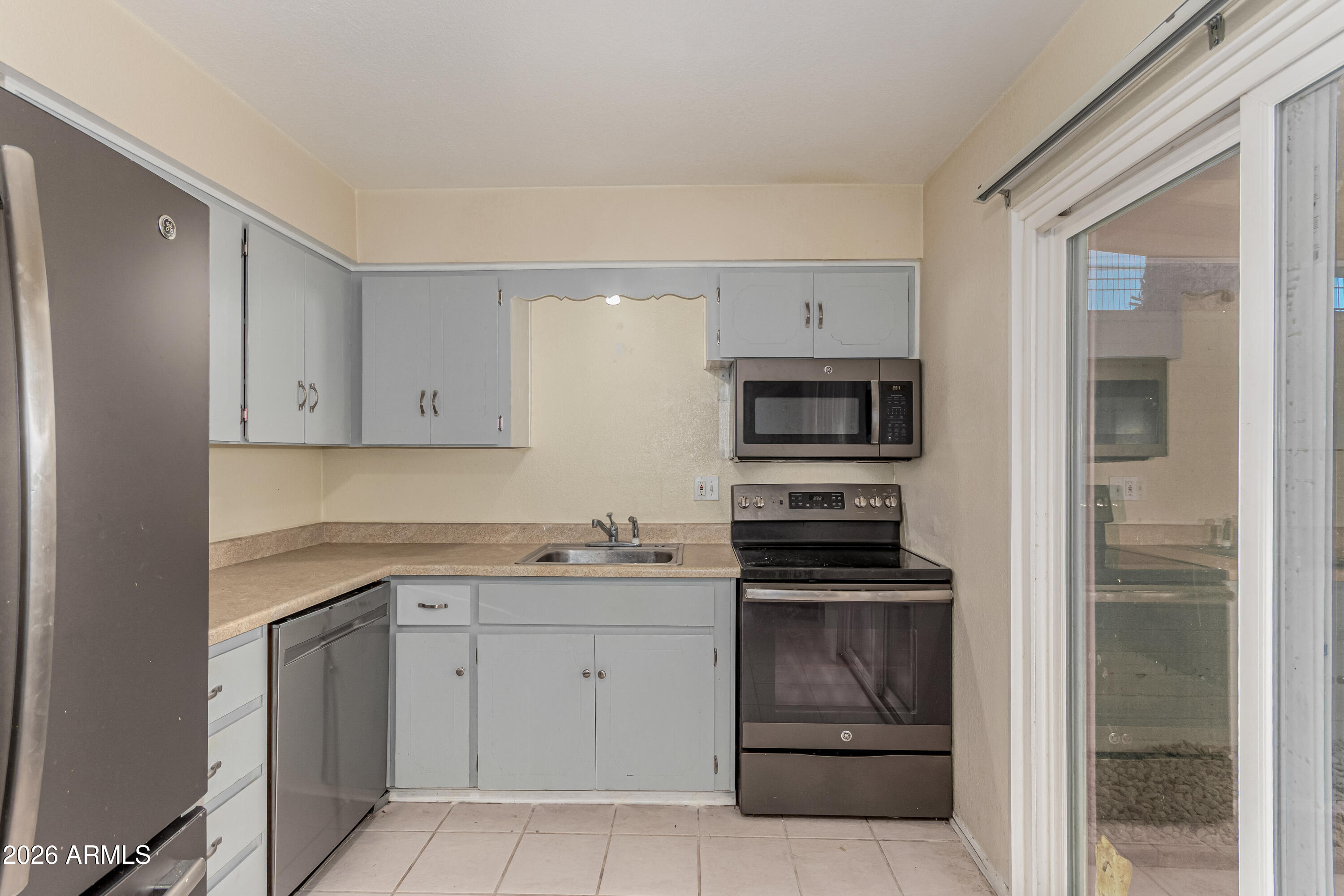 1531 West Colter Street, Unit 1 Phoenix, AZ 85015 - Photo 7 of 32 a kitchen with white cabinets and stainless steel appliances