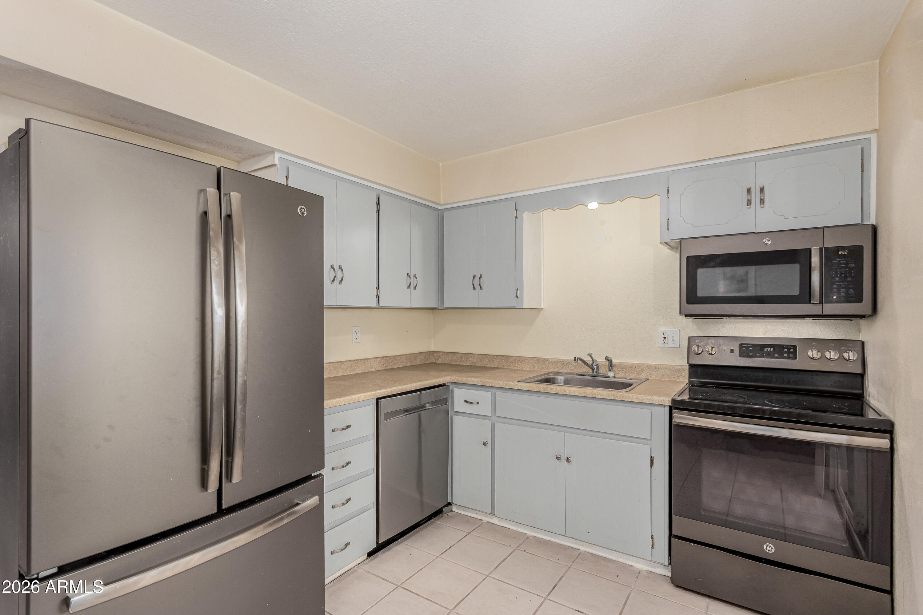 1531 West Colter Street, Unit 1 Phoenix, AZ 85015 - Photo 8 of 32 a kitchen with white cabinets stainless steel appliances and sink