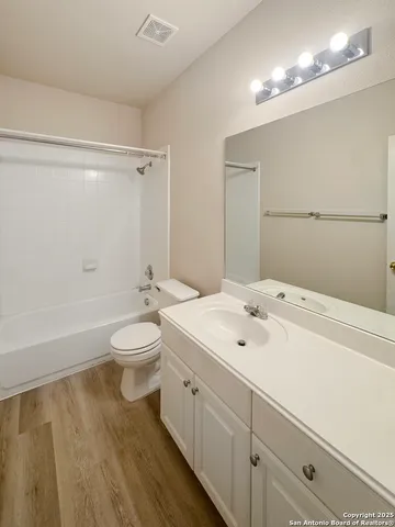 a view of a kitchen with wooden floor and cabinets