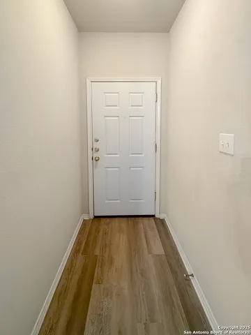 an empty room with wooden floor and a ceiling fan