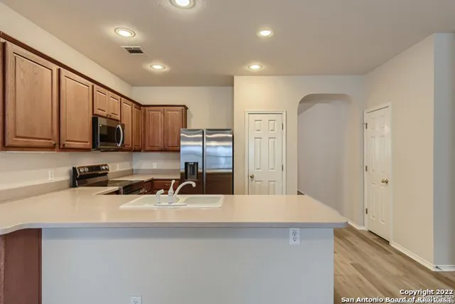 a kitchen with refrigerator cabinets and wooden floor