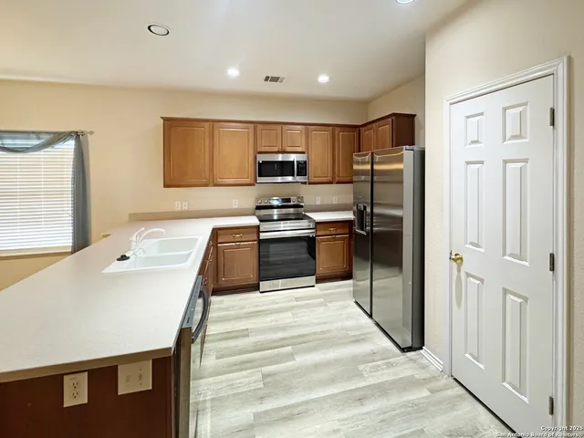 a kitchen with stainless steel appliances granite countertop a refrigerator sink and cabinets