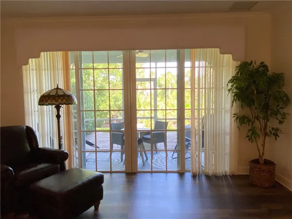 a living room with furniture and a large window with wooden floor