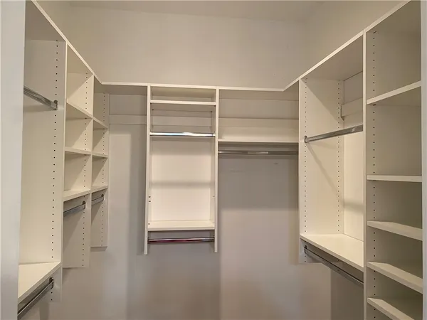 a view of walk in closet with empty racks