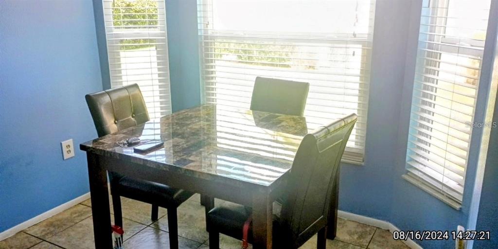 11543 Orleans Lane, Unit 11543 Port Richey, FL 34668 - Photo 4 of 13 a view of a dining room with furniture and a window